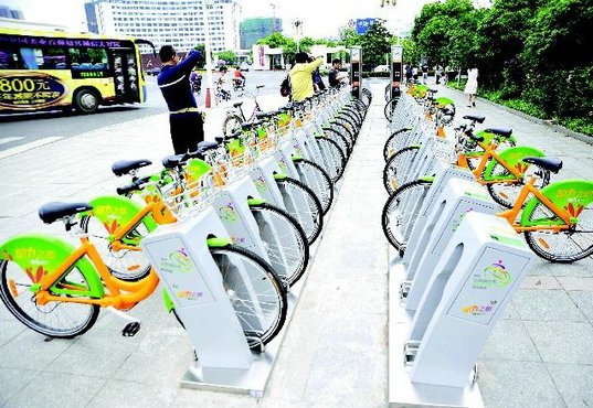 公共自行车租赁就是在某个区域内(城市或者大学城等),隔一定距离规划出一些停放自行车的点(比如地铁出口,社区大门口等),一般一个租赁点放置30-60辆左右。那么一个城市就会象公交车站点和地铁站点一样,有很多自行车租赁点。通过公共自行车管理系统来管理这些租赁点的自行车,每辆自行车都单独有一个可以锁自行车的装置和读卡租车、还车的读卡器(固定在地上的,不能移动)。每次租车把卡放到上面读一下,锁就开了,自行车就可以骑走了;骑到任何一个其它租赁点都可以还车,因为系统是连网的。还车时把车放到锁的位置,把卡靠近读卡